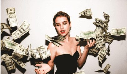 A girl standing with money blowing around her