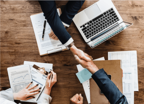 Two people shaking hands as an agreement at a sales meeting