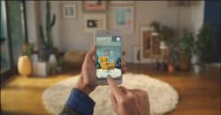 Person holding up a smartphone and a living room in the background. On the smartphone's screen, a yellow IKEA armchair is projected using augmented reality on the image of the living room.